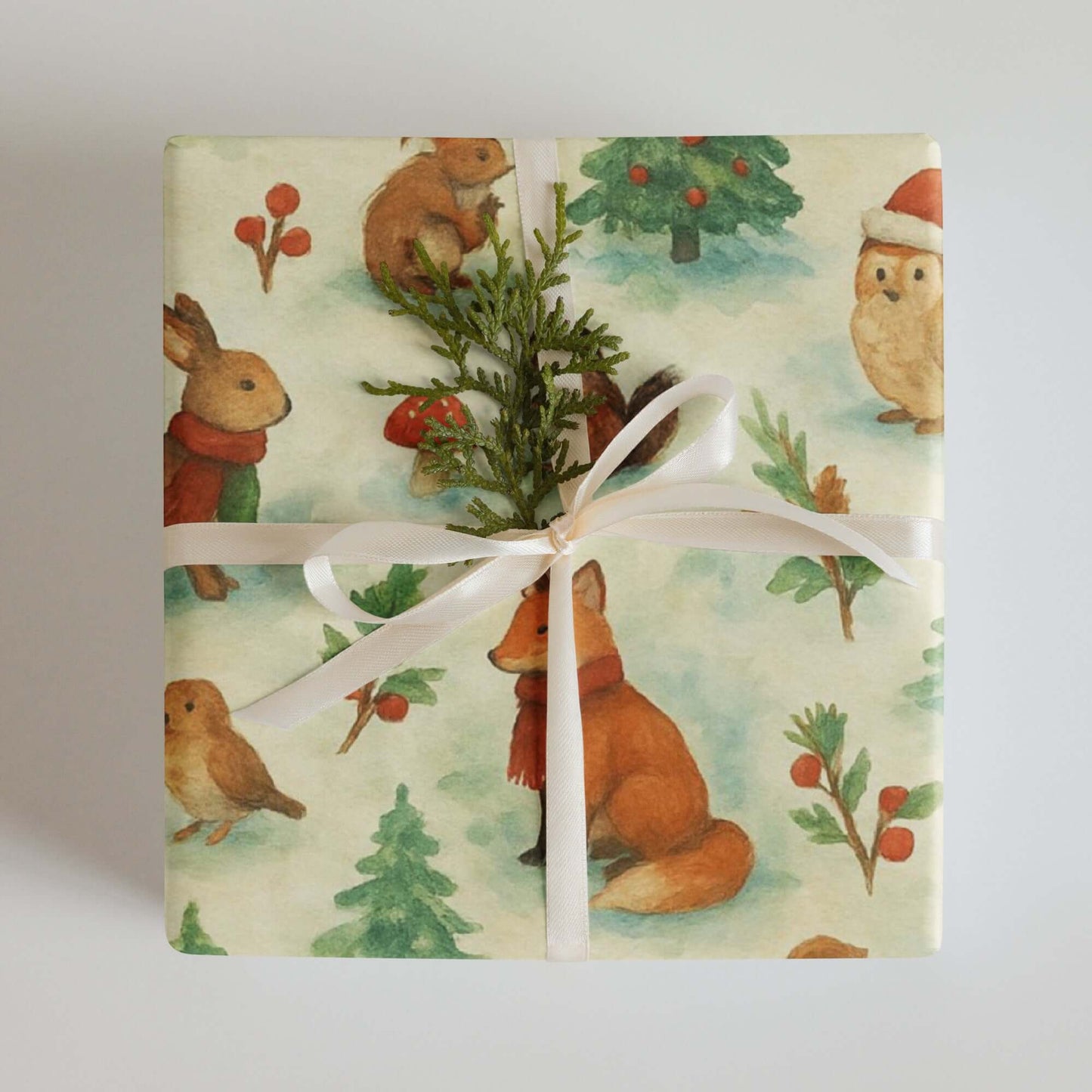 Luxury Christmas wrapping paper featuring watercolor woodland animals and a festive bow.