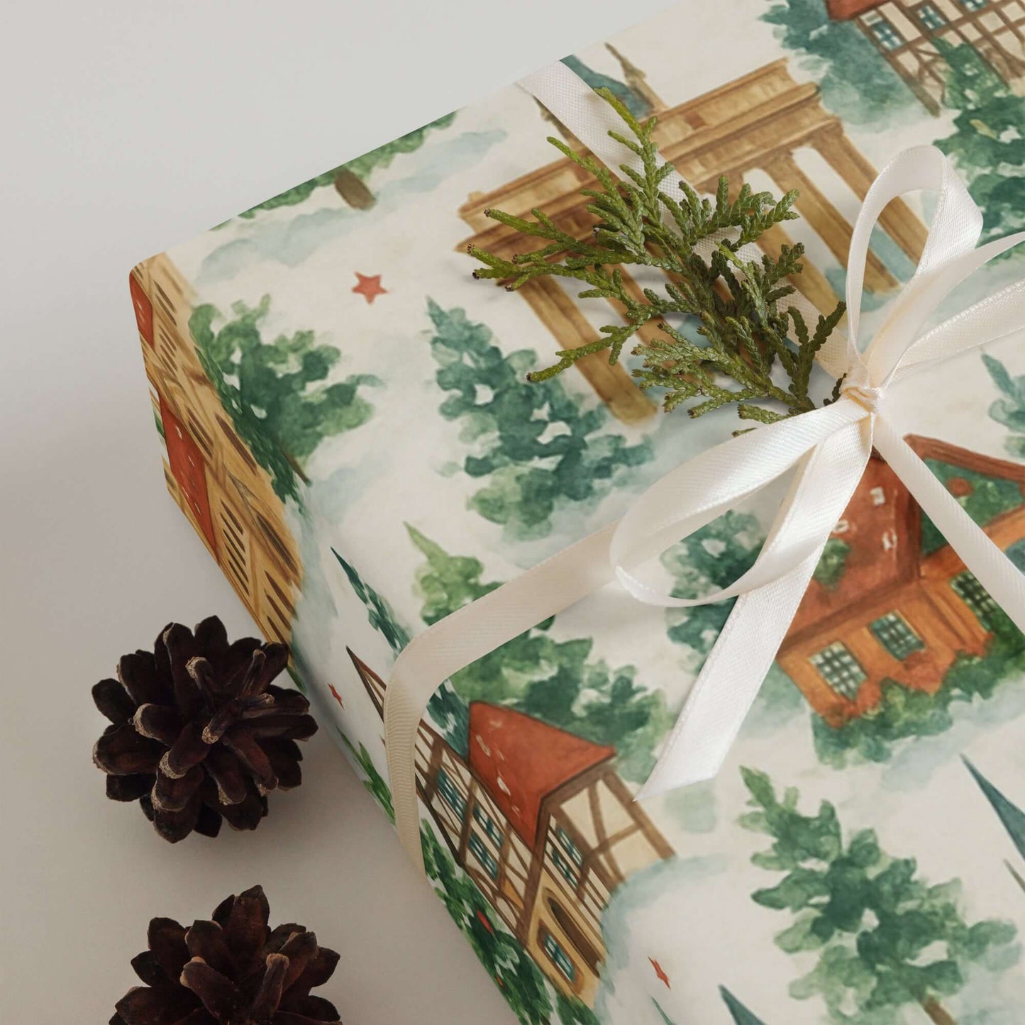 Luxury Christmas wrapping paper featuring watercolor landmarks, winter trees, and festive houses.