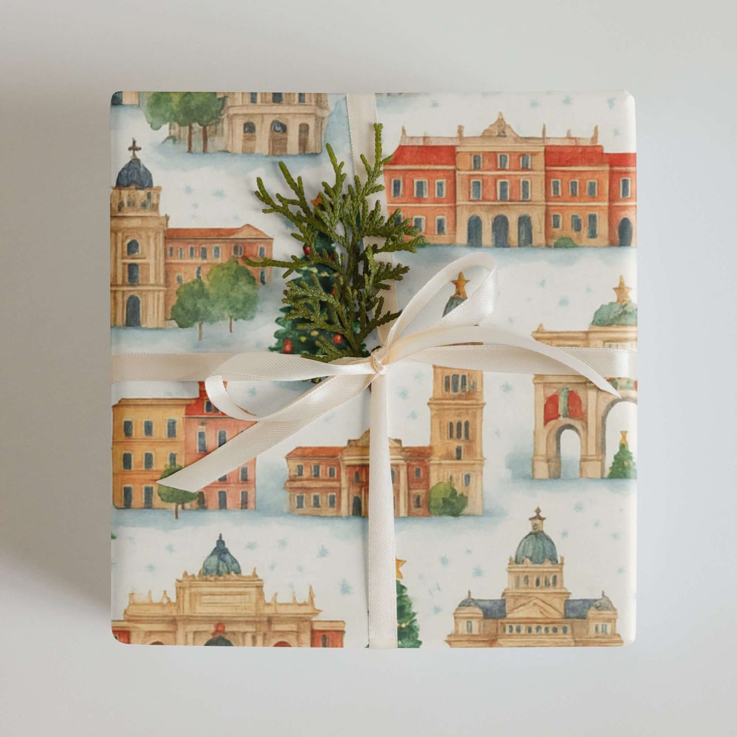 Luxury Christmas wrapping paper featuring Madrid landmarks in watercolor design, adorned with greenery and ribbon.