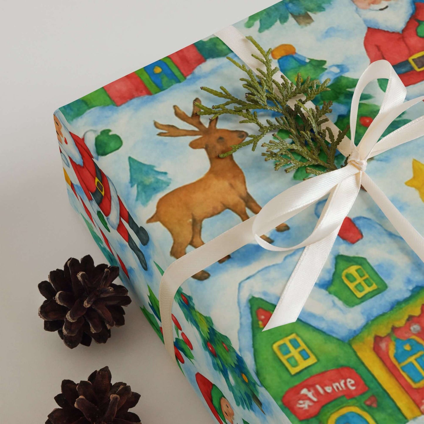Luxury Christmas wrapping paper featuring Santa's Village design with reindeer and colorful holiday cottages.