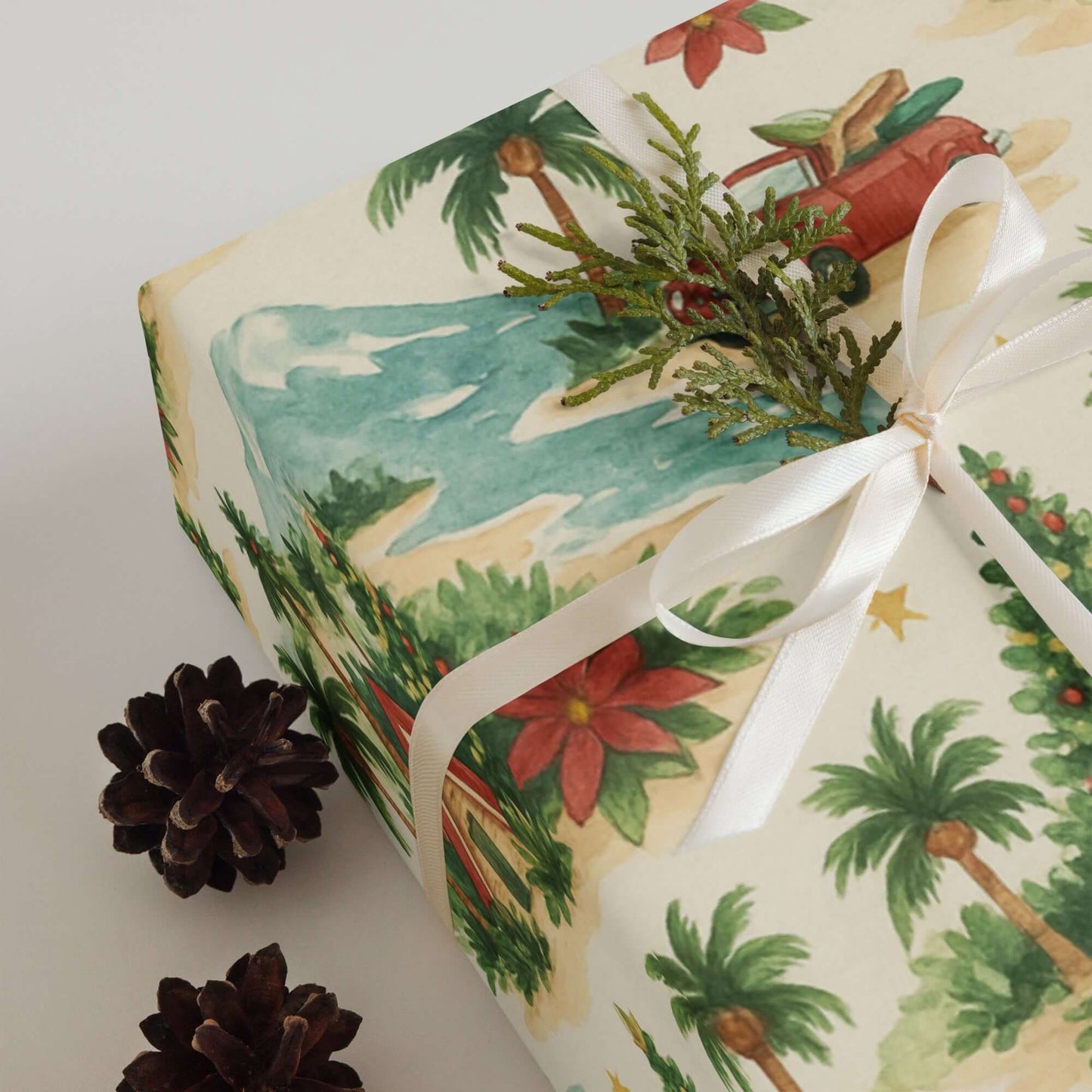 Luxury Mele Kalikimaka wrapping paper with tropical design, tied with ribbon and pinecones, perfect for holiday gift wrap.