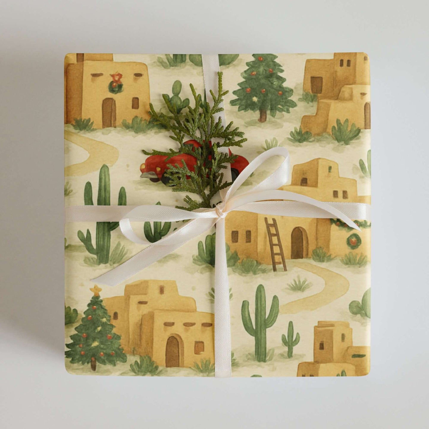 Adobe Pueblo Christmas wrapping paper featuring desert homes, cacti, and festive wreaths, perfect for holiday gift wrap.