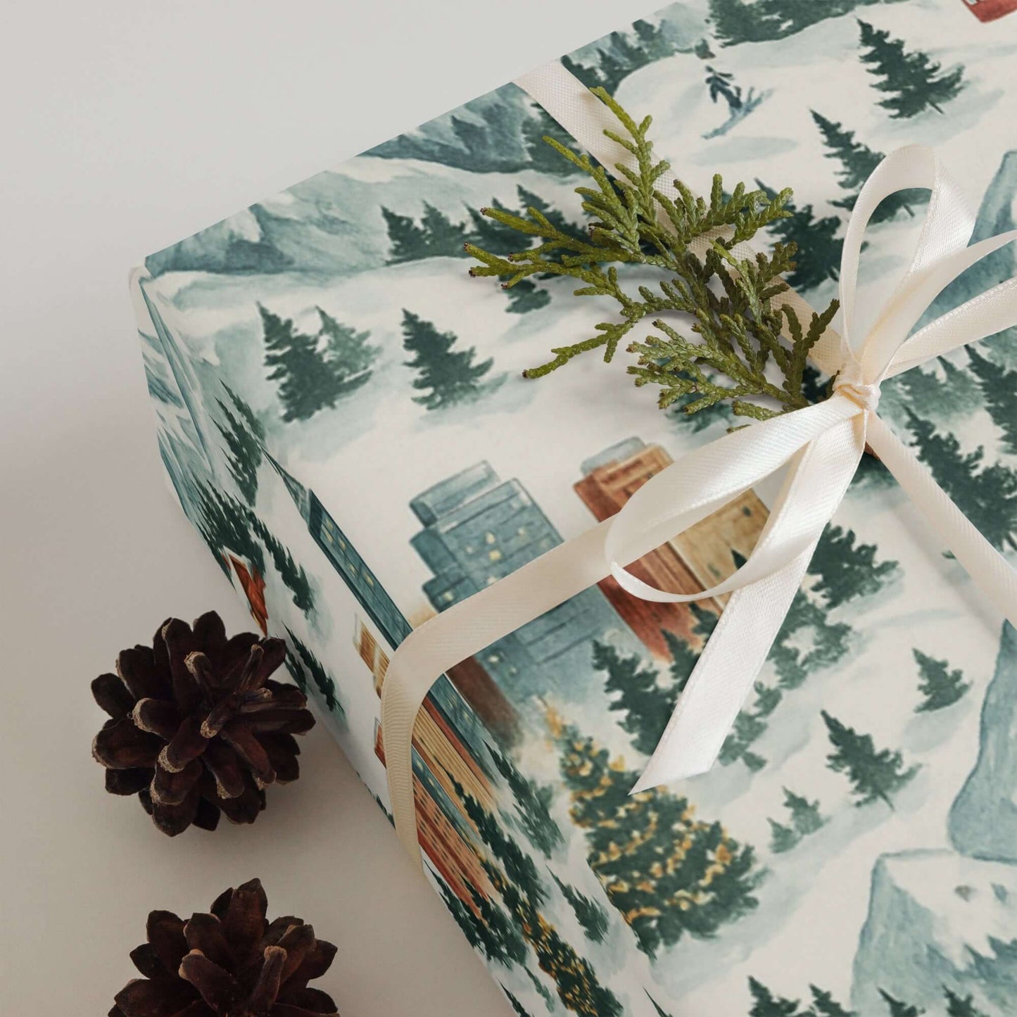 Luxury Christmas wrapping paper featuring watercolor mountain landscapes and pine accents, perfect for holiday gifting.