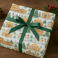 Luxury Christmas wrapping paper featuring watercolor landmarks of Rome, beautifully styled with a green ribbon.