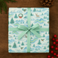 Luxury Christmas wrapping paper featuring watercolor Arctic wildlife and festive designs, tied with a mint green ribbon.