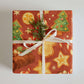 Baking Christmas Wrapping Paper featuring festive holiday designs of cookies, trees, and candy canes on a rich red background.