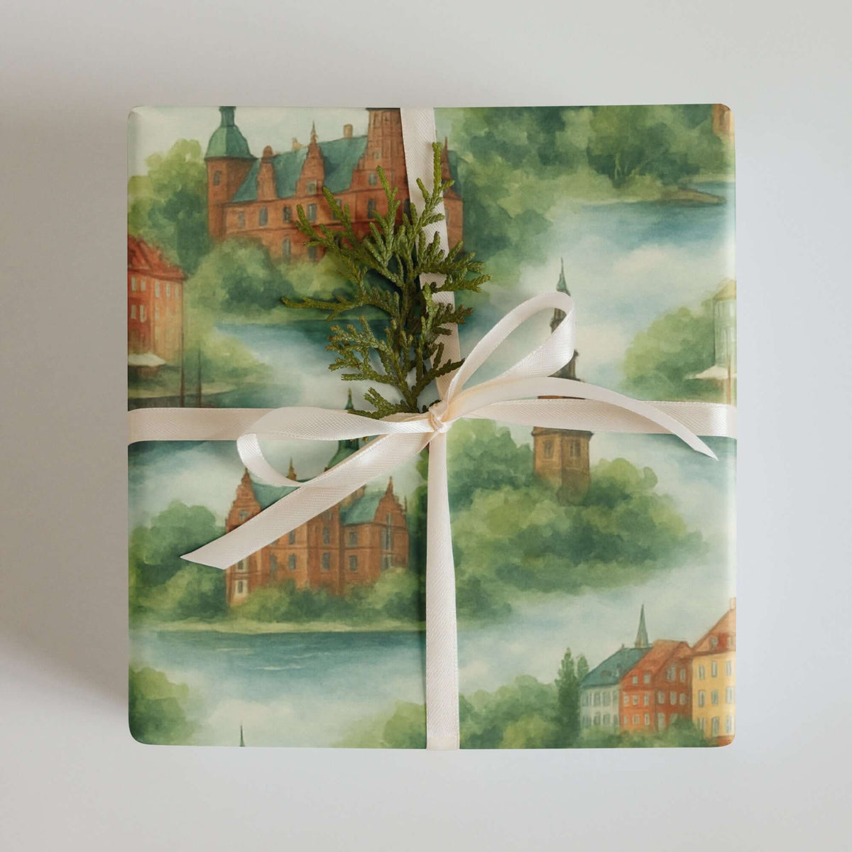 Denmark Wrapping Paper featuring soft watercolor cityscapes with a bow and greenery, perfect for elegant gift wrapping.