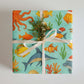 Luxury holiday gift wrap featuring colorful sea creatures and coral design in watercolor style.