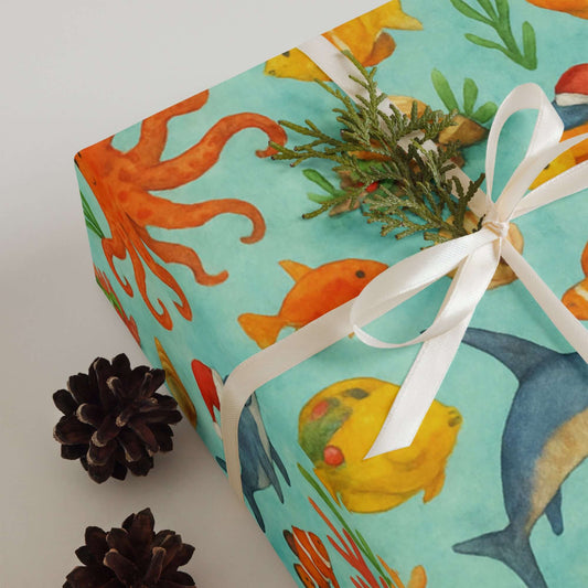 Luxury holiday gift wrap featuring vibrant watercolor sea creatures and tropical fish design.