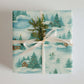 Skating Winter Christmas Wrapping Paper featuring skaters, cabin, evergreens, and snowmen in a watercolor design.