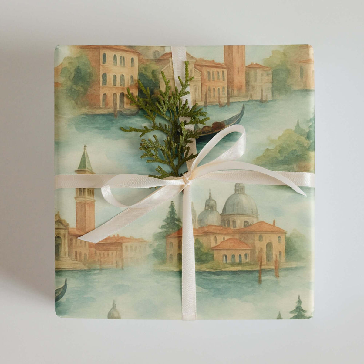 Venice Wrapping Paper featuring watercolor illustrations of Venetian architecture and gondolas tied with a ribbon and greenery.