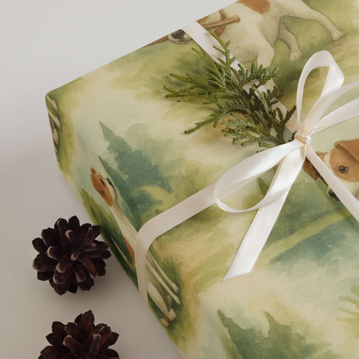 Jack Russells Wrapping Paper featuring playful Jack Russell terriers on a beautifully wrapped gift with pine cones.