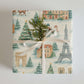 Luxury Christmas wrapping paper featuring Paris landmarks in watercolor design, adorned with greenery and festive elements.