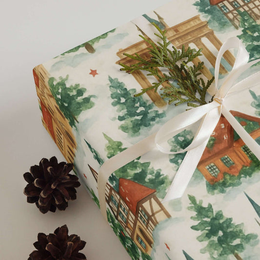 Luxury Christmas wrapping paper featuring watercolor landmarks, winter trees, and festive houses.