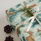 Luxury Alaska Christmas wrapping paper features watercolor design with rustic cabins, wildlife, and winter scenes, perfect for holiday gift wrap.