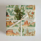 Luxury Christmas wrapping paper featuring watercolor desert landscapes and festive holiday motifs.