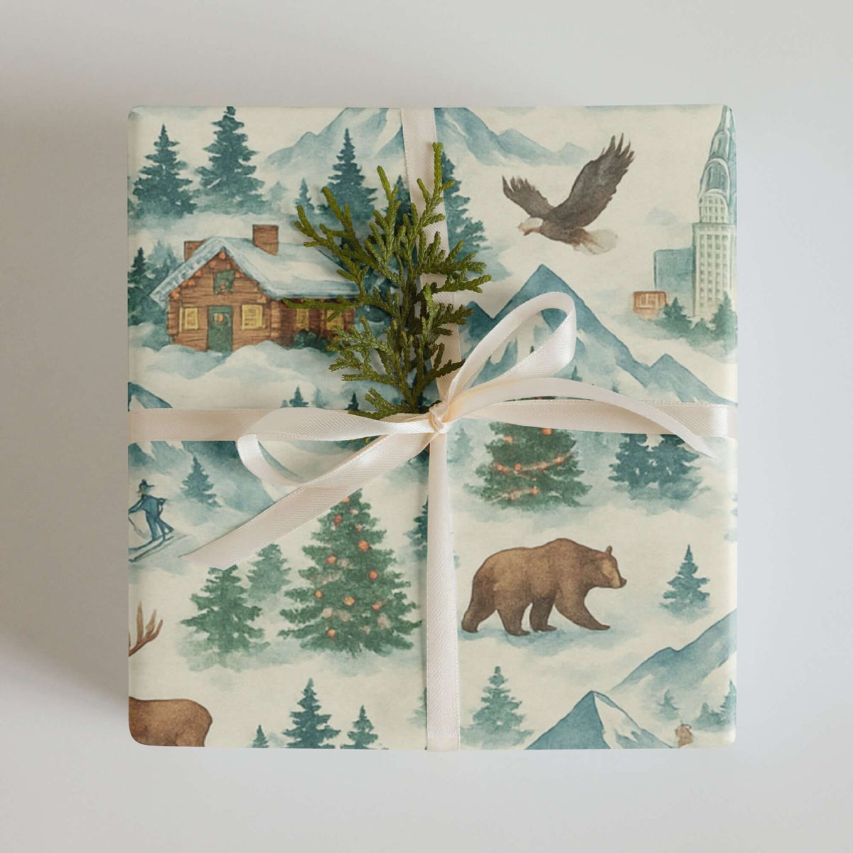Luxury Rockies Christmas wrapping paper featuring watercolor mountain scenes and rustic cabins with holiday elements.