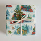 Luxury Christmas wrapping paper featuring vibrant watercolor train design, enhanced with natural greenery.