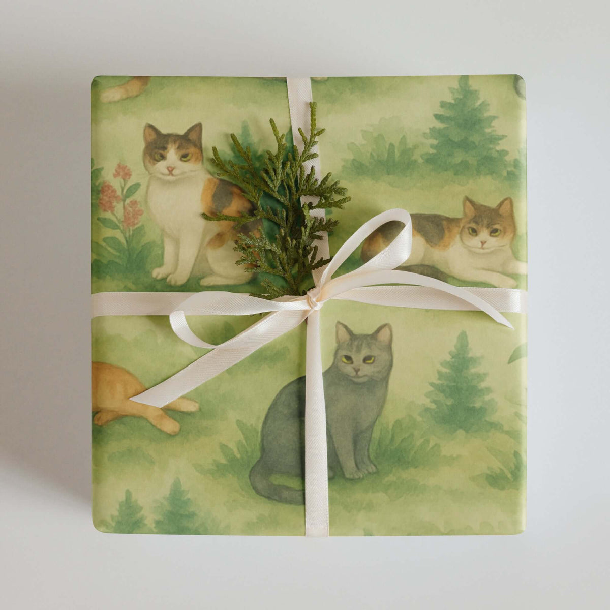 Cats Wrapping Paper featuring a variety of cats lounging and sitting among soft greenery, tied with a ribbon.